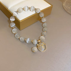 Gold-plated bracelet collection with pearls, cat’s eye stones, and floral motifs