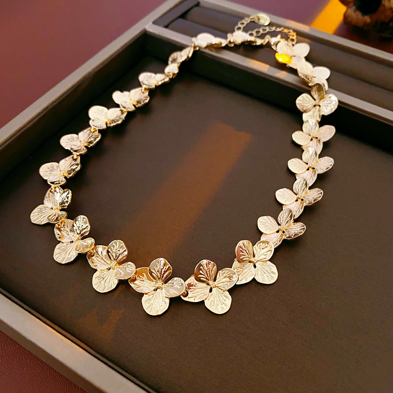 Golden Petal Elegance Set with necklace, bracelet, and earrings featuring golden floral petal details