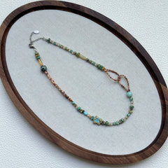 Full view of Sage Loop Blossom Necklace hanging – handcrafted dune palette with modern asymmetrical loop detail