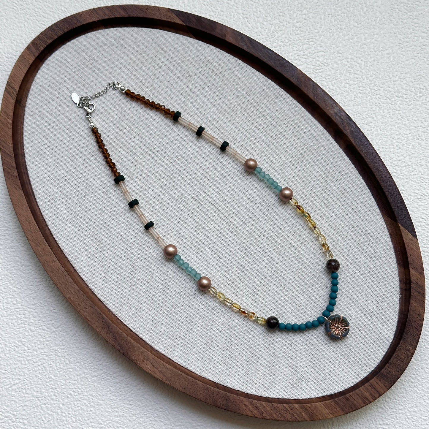 Full view of Lagoon Sunburst Necklace hanging – handcrafted coastal palette of lagoon blue and gold with sunburst focal