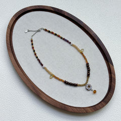 Amber Daisy Necklace displayed on an oval tray – delicate amber–gold palette with daisy pendant and petite amber drop