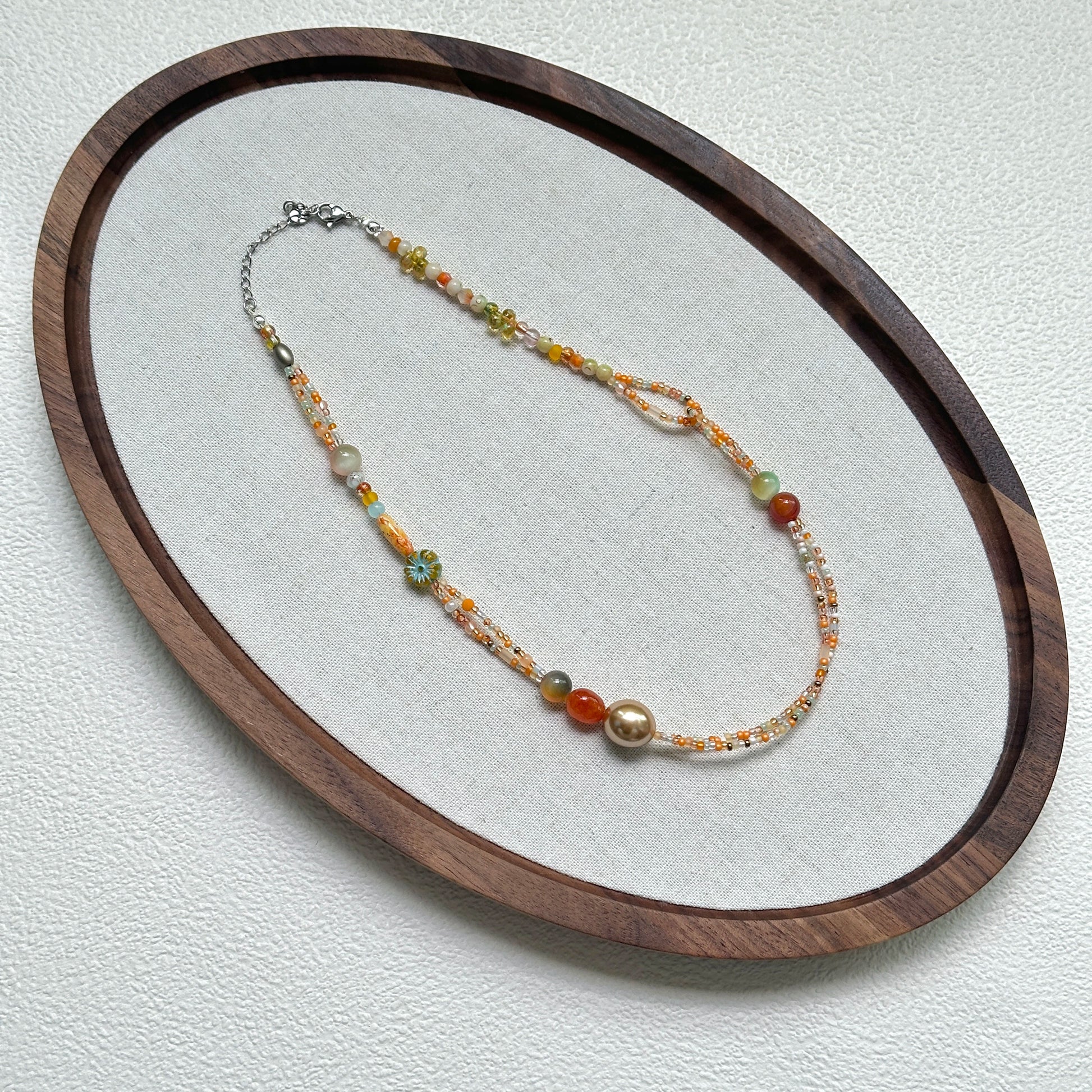 Golden Ember Necklace flat lay with delicate gold and amber beads