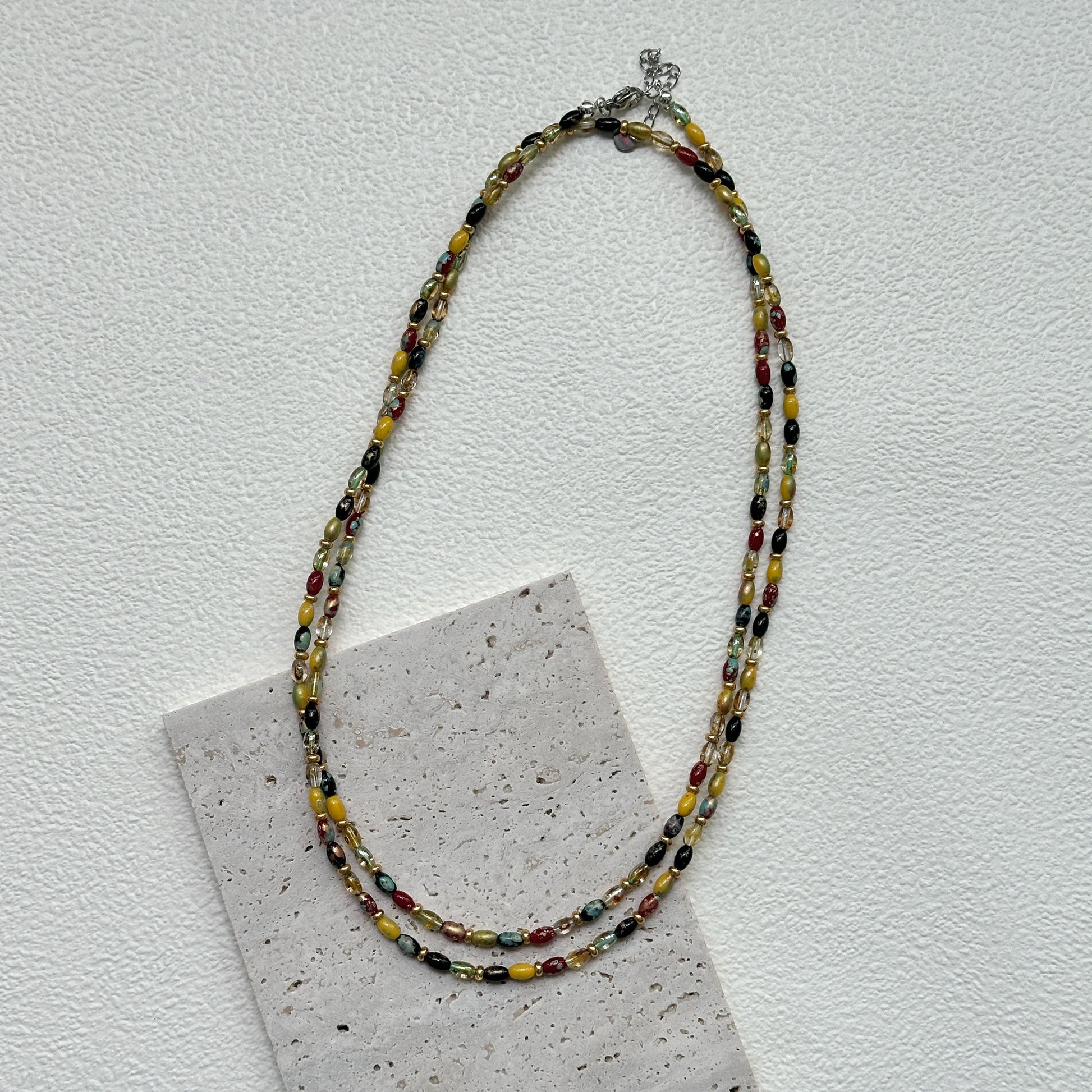 Tribal Glow Necklace close-up – handmade beaded necklace featuring red, yellow, green, and black glass beads by Glazenya
