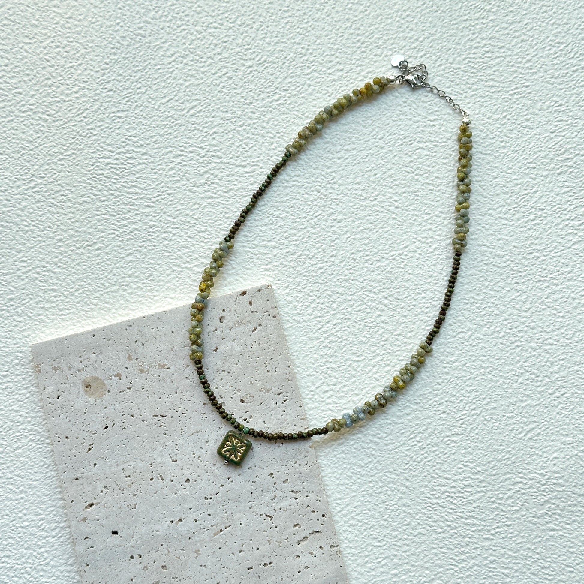 Handcrafted Gilded Bloom Necklace laid flat showing gold-accented beads and floral charm2