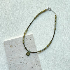 Handcrafted Gilded Bloom Necklace laid flat showing gold-accented beads and floral charm2