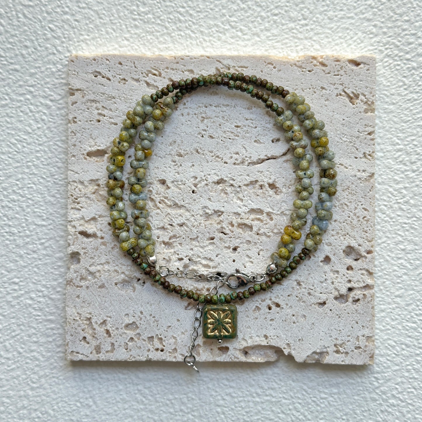 Handcrafted Gilded Bloom Necklace laid flat showing gold-accented beads and floral charm3