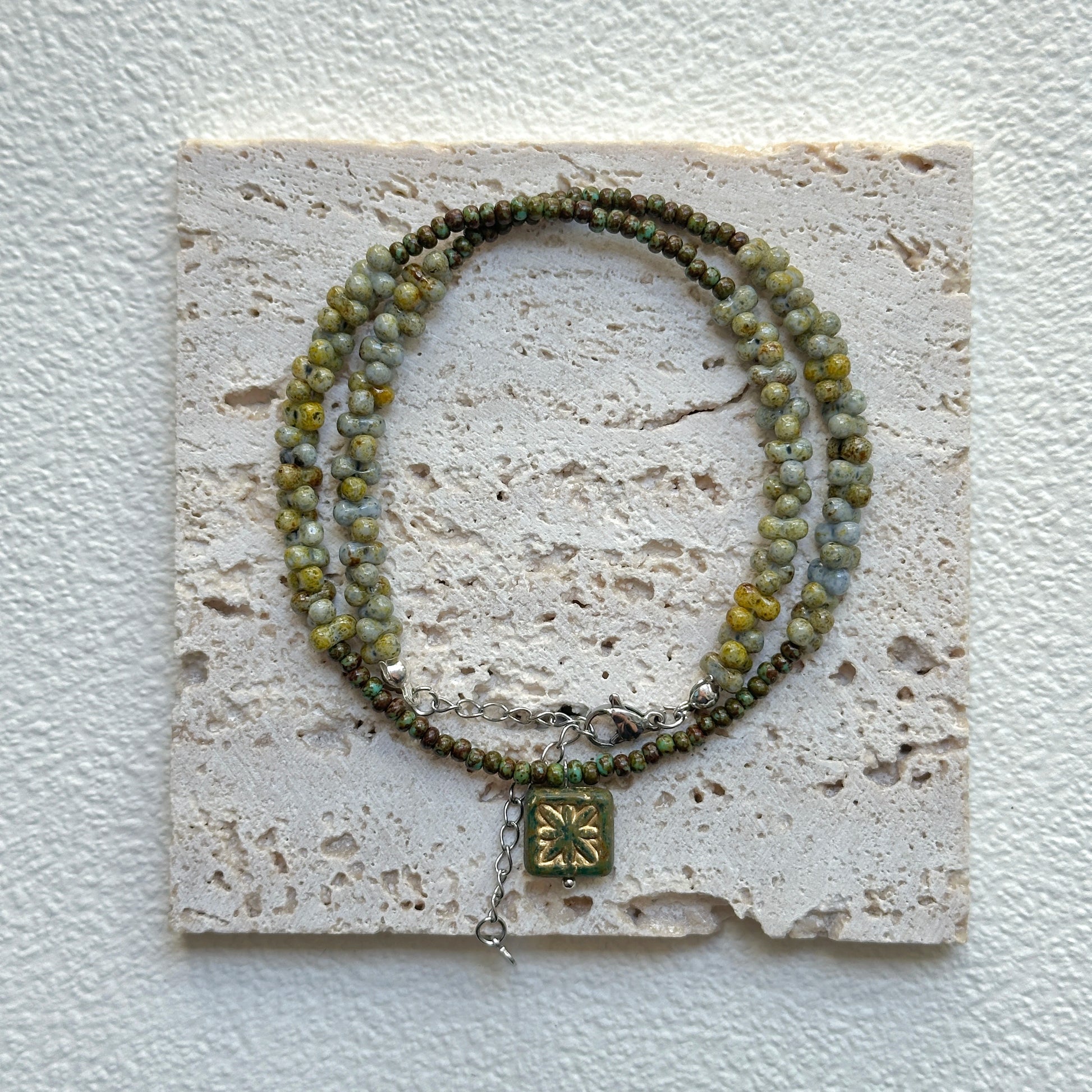 Handcrafted Gilded Bloom Necklace laid flat showing gold-accented beads and floral charm3