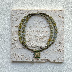 Handcrafted Gilded Bloom Necklace laid flat showing gold-accented beads and floral charm3