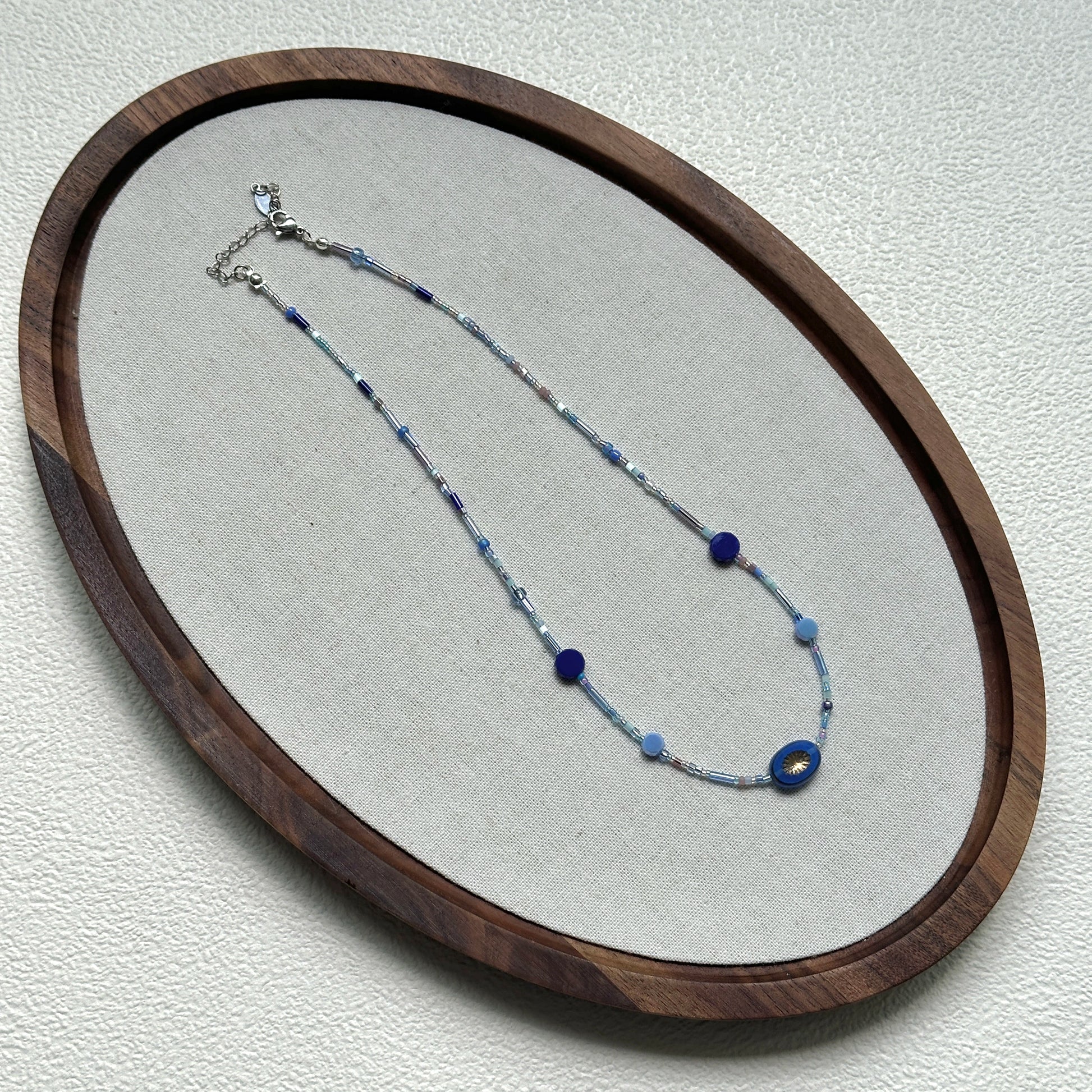 Handcrafted Celestial Wave Necklace laid flat showing silver, light blue, and dark blue beads2
