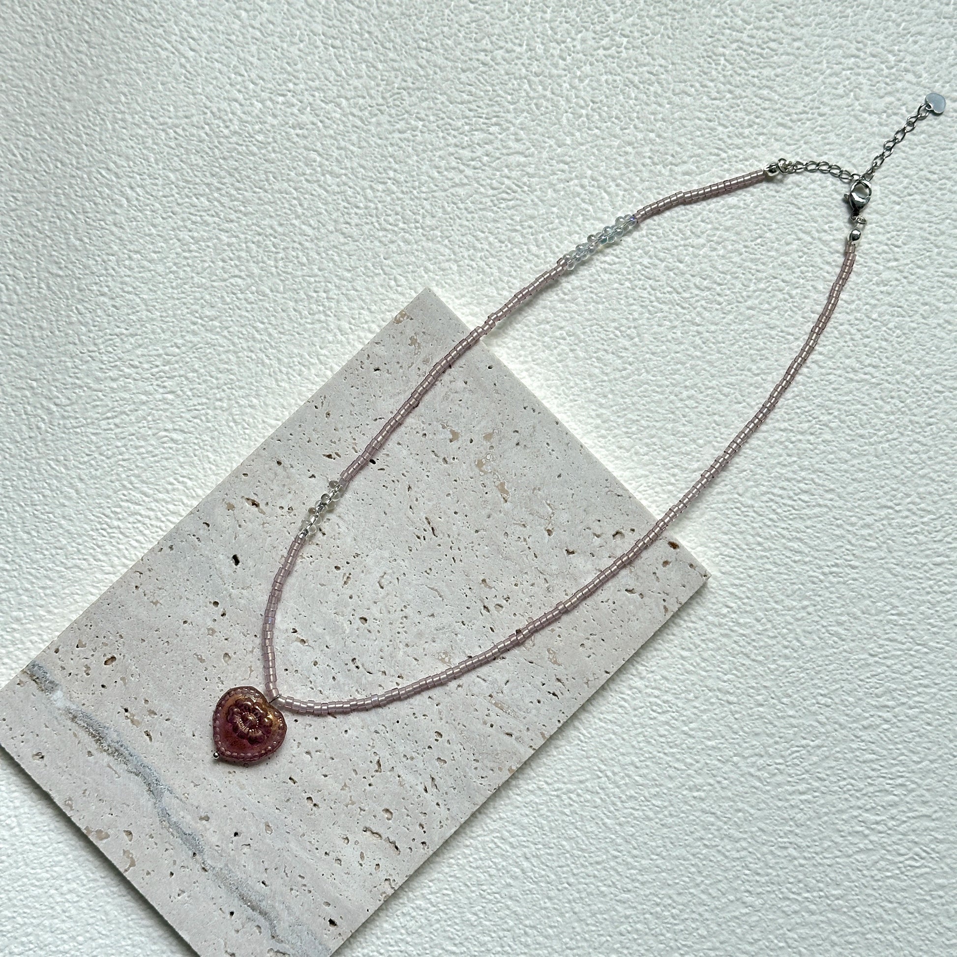Close-up of Pink Serenade Necklace with heart-shaped pendant and blush beads