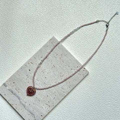 Close-up of Pink Serenade Necklace with heart-shaped pendant and blush beads