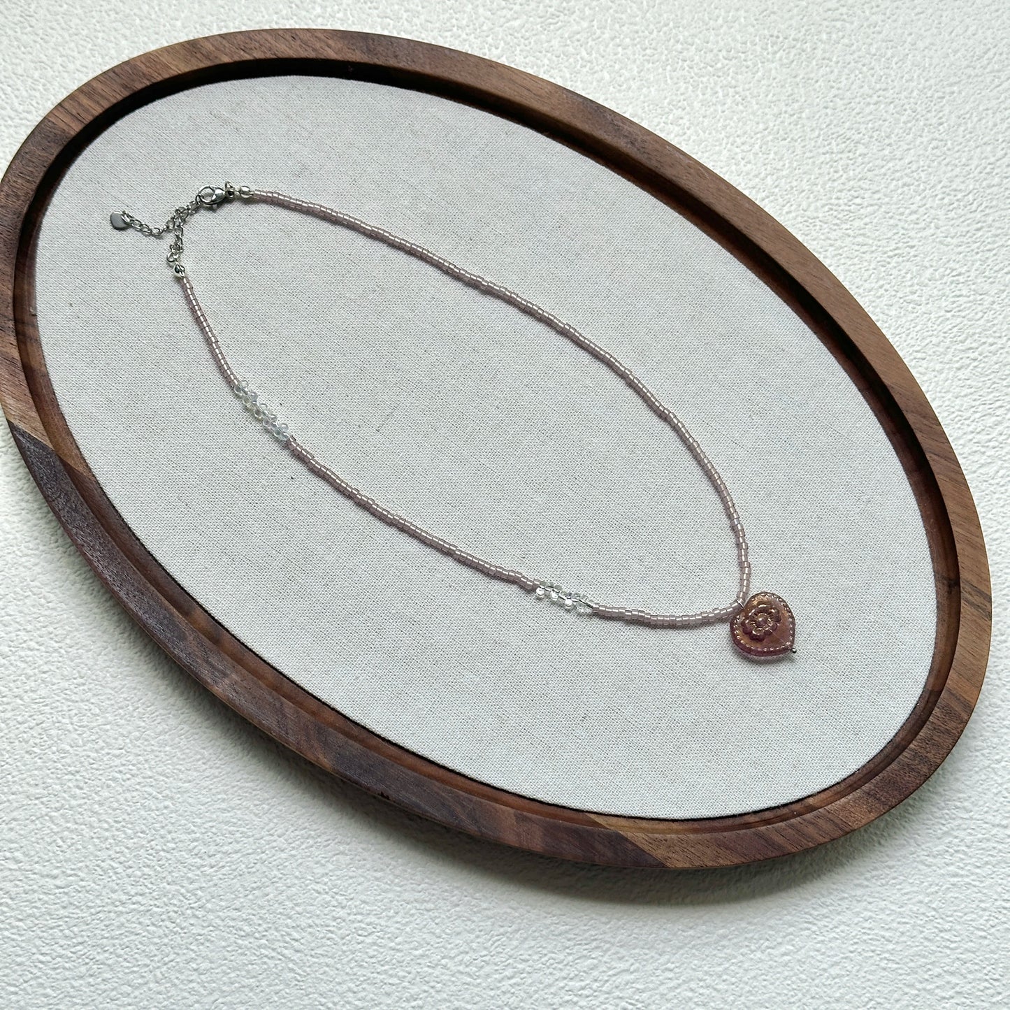 Pink Serenade Necklace styled on a glass display with delicate handcrafted details