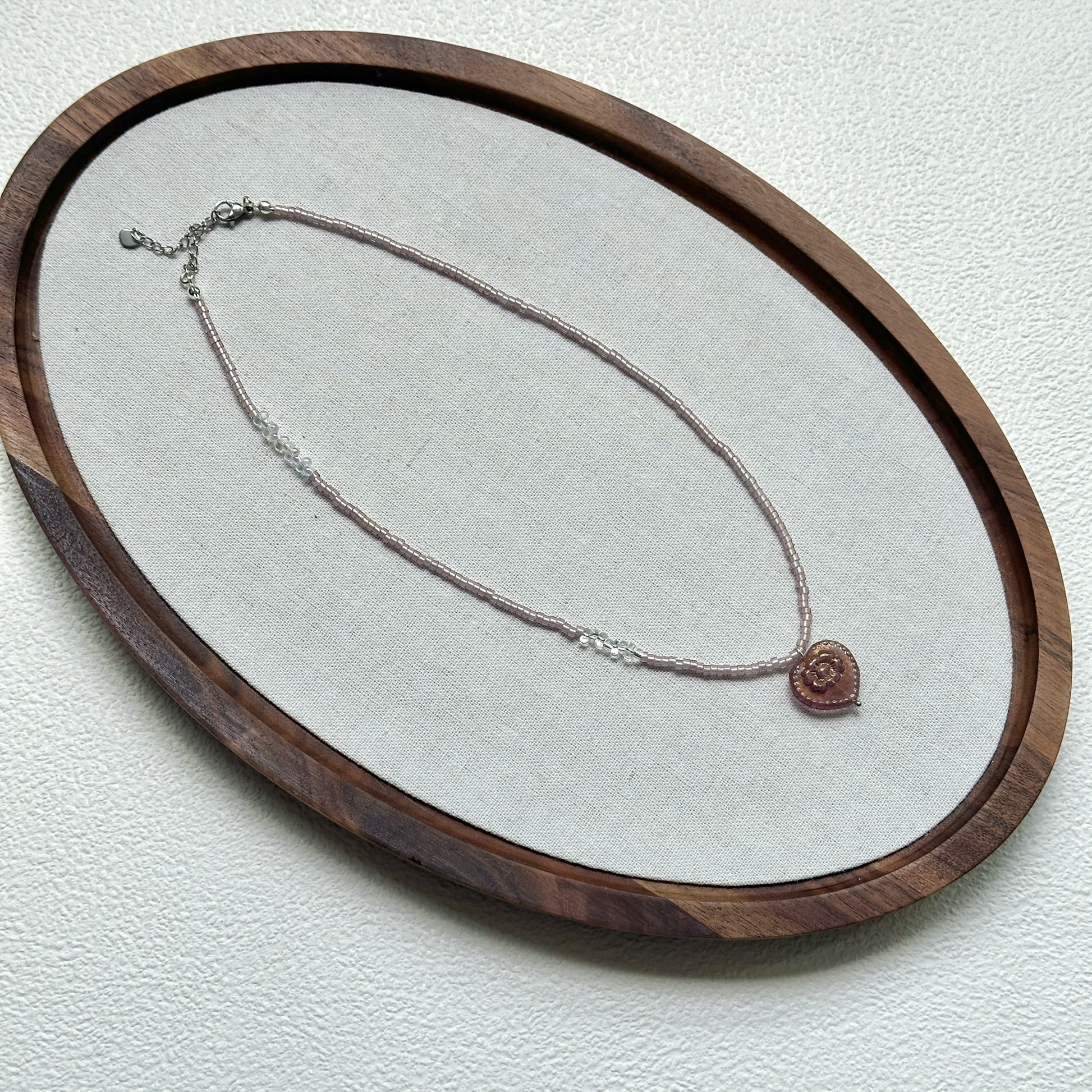 Pink Serenade Necklace styled on a glass display with delicate handcrafted details