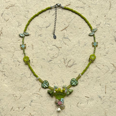 Limeleaf Bouquet Necklace — circle layout on neutral textured paper showing bead palette and bouquet-style charm