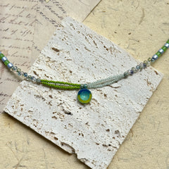 Citrus Wave Necklace — close-up highlighting striped beads and the wave medallion