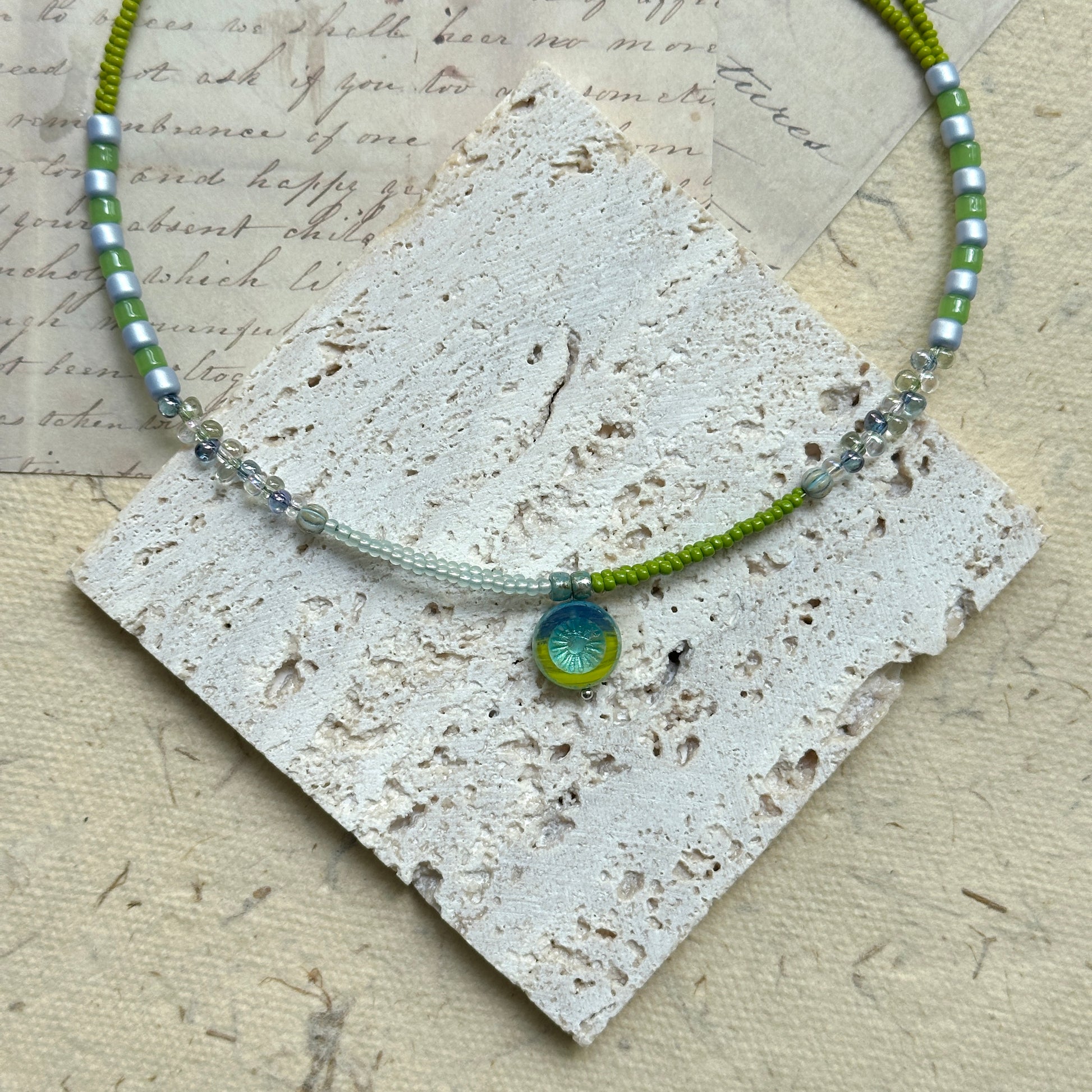 Citrus Wave Necklace — close-up highlighting striped beads and the wave medallion1