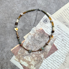 Sage & Saffron Necklace — circle layout on vintage papers; sage-green and saffron-amber palette with speckled hearts and cube focal