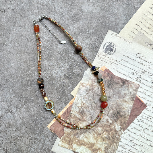 Marigold Mosaic Necklace — circle layout on neutral background showing asymmetric bead placement and floral coin detail