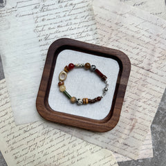 Spice Caravan Bracelet — circle layout on textured background showing warm saffron/amber palette and sunburst charm