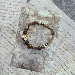 Speckled Honey Heart Bracelet — circle layout on textured background showing warm neutral palette and heart focal