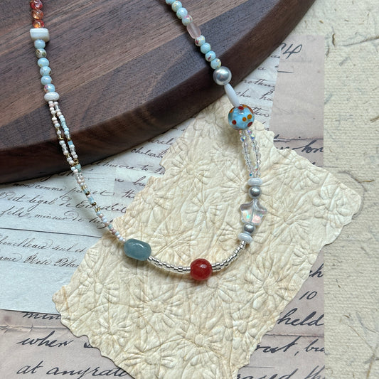 Candy Sky Necklace — angled close-up on textured paper showing the star charm and polka-dot lampwork bead detail