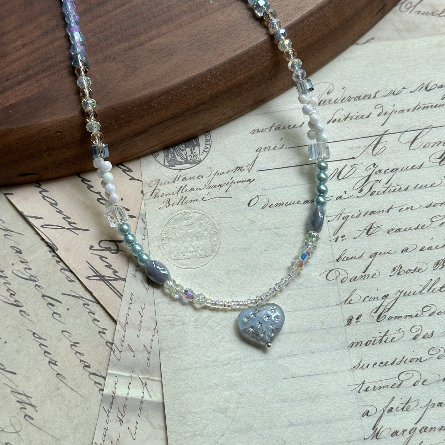 Moonlit Heart Necklace — close-up of the heart-shaped centerpiece; crystal, pearl, and glass beads in soft icy blue