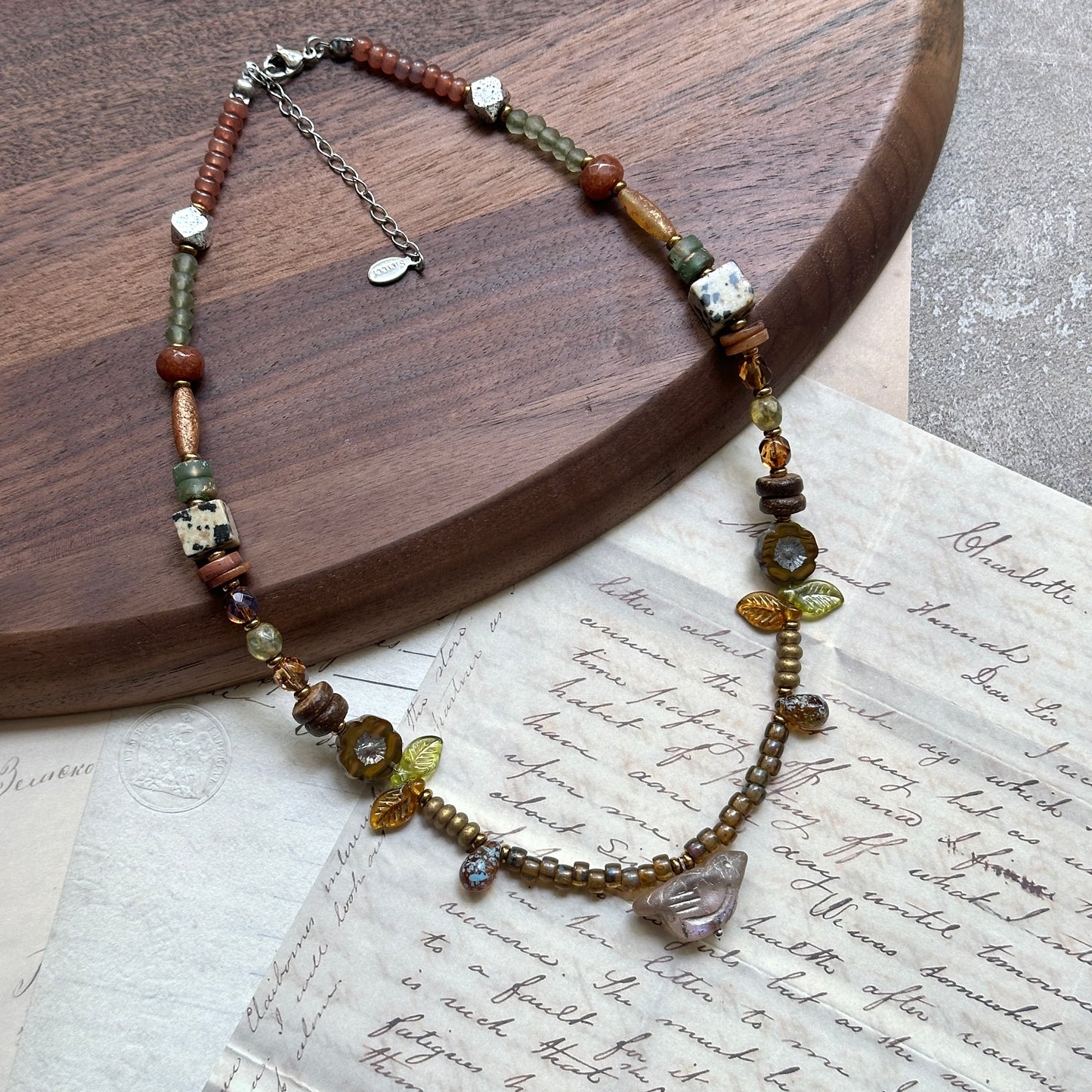 Amber Leaf Trail Necklace — close-up of leaf accents, faceted amber beads, and clear pendant