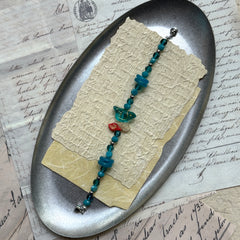 Handcrafted blue beaded bracelet with red leaf accent, nature-inspired jewelry