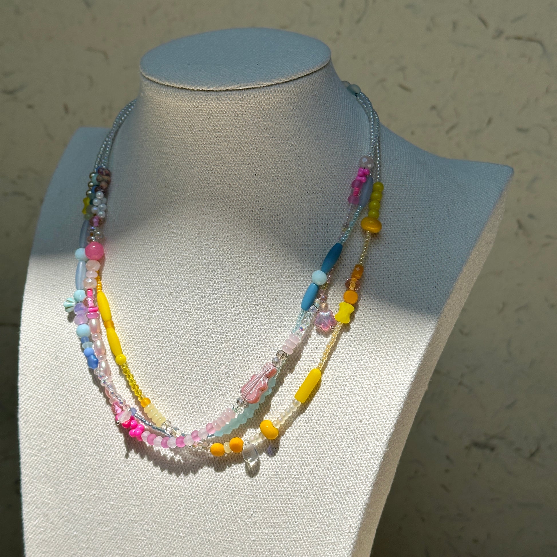 Sunshine Confetti Necklace worn on bust, highlighting joyful mix of pastel beads and crystal accents with layered silhouette