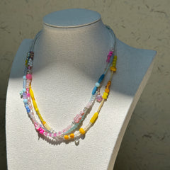 Sunshine Confetti Necklace worn on bust, highlighting joyful mix of pastel beads and crystal accents with layered silhouette