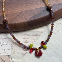 Handmade necklace with crimson apple charm and twilight purple–gold beads – Glazenya