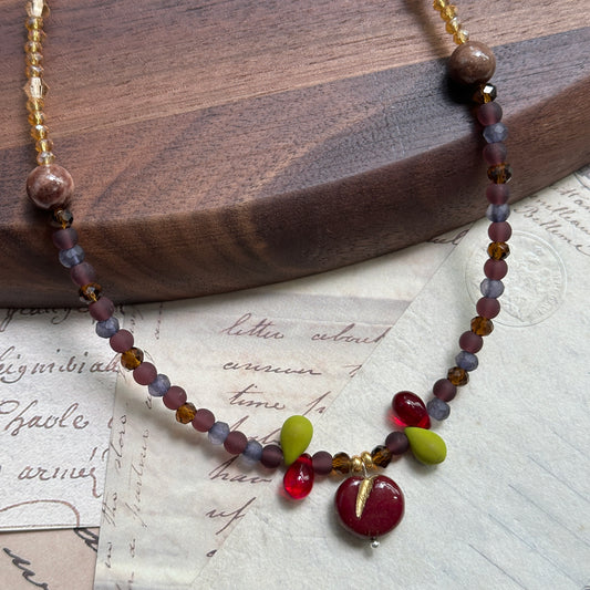Handmade necklace with crimson apple charm and twilight purple–gold beads – Glazenya