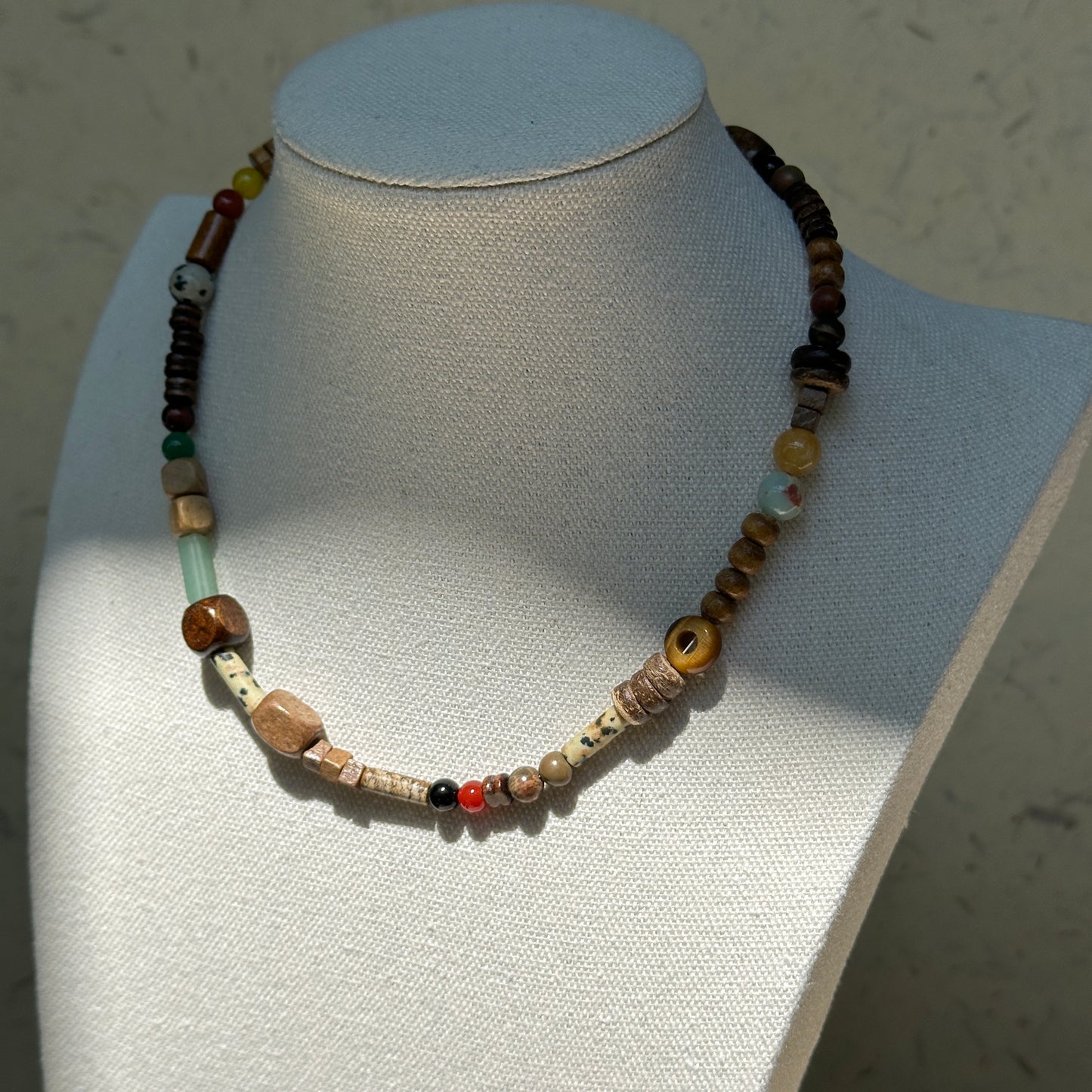 Desert Caravan Necklace worn on bust, showcasing earthy desert colors with wood, ceramic, and glass bead textures