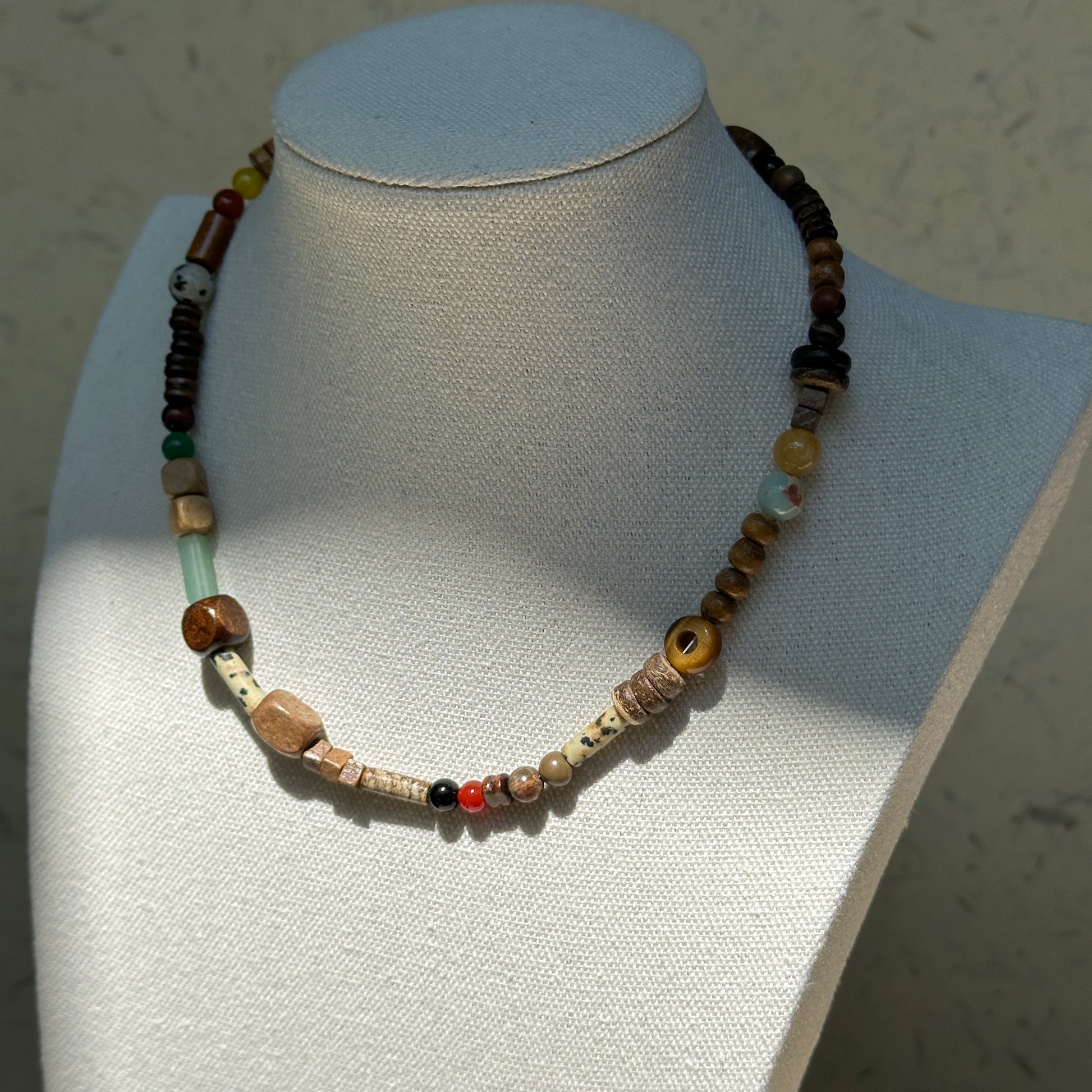 Desert Caravan Necklace worn on bust, showcasing earthy desert colors with wood, ceramic, and glass bead textures