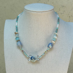 Ocean Whisper Necklace worn on bust, featuring soothing aqua and white palette with glass penguin and jellyfish charms for a coastal style
