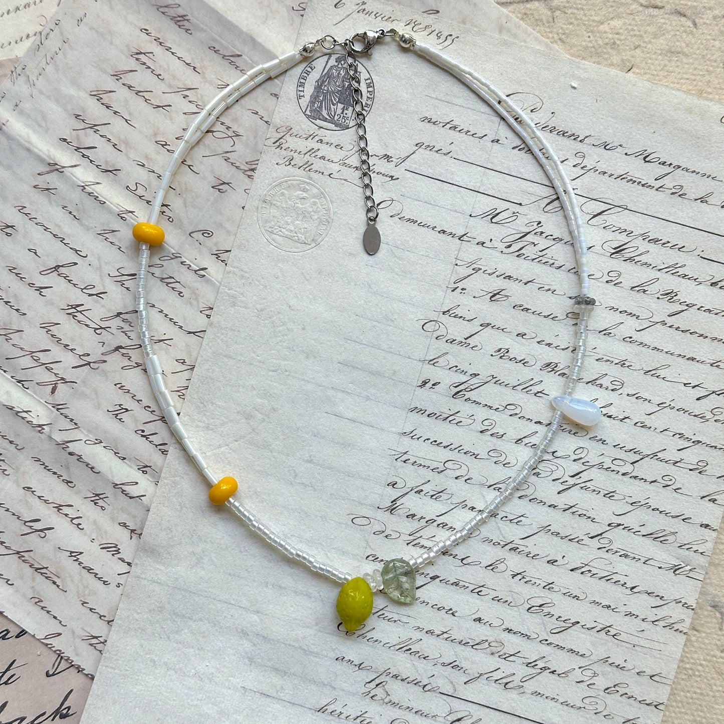 Close-up of lemon-shaped glass bead with translucent leaf charm