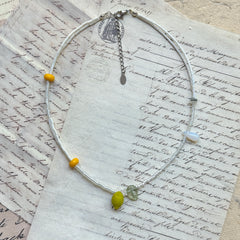Close-up of lemon-shaped glass bead with translucent leaf charm