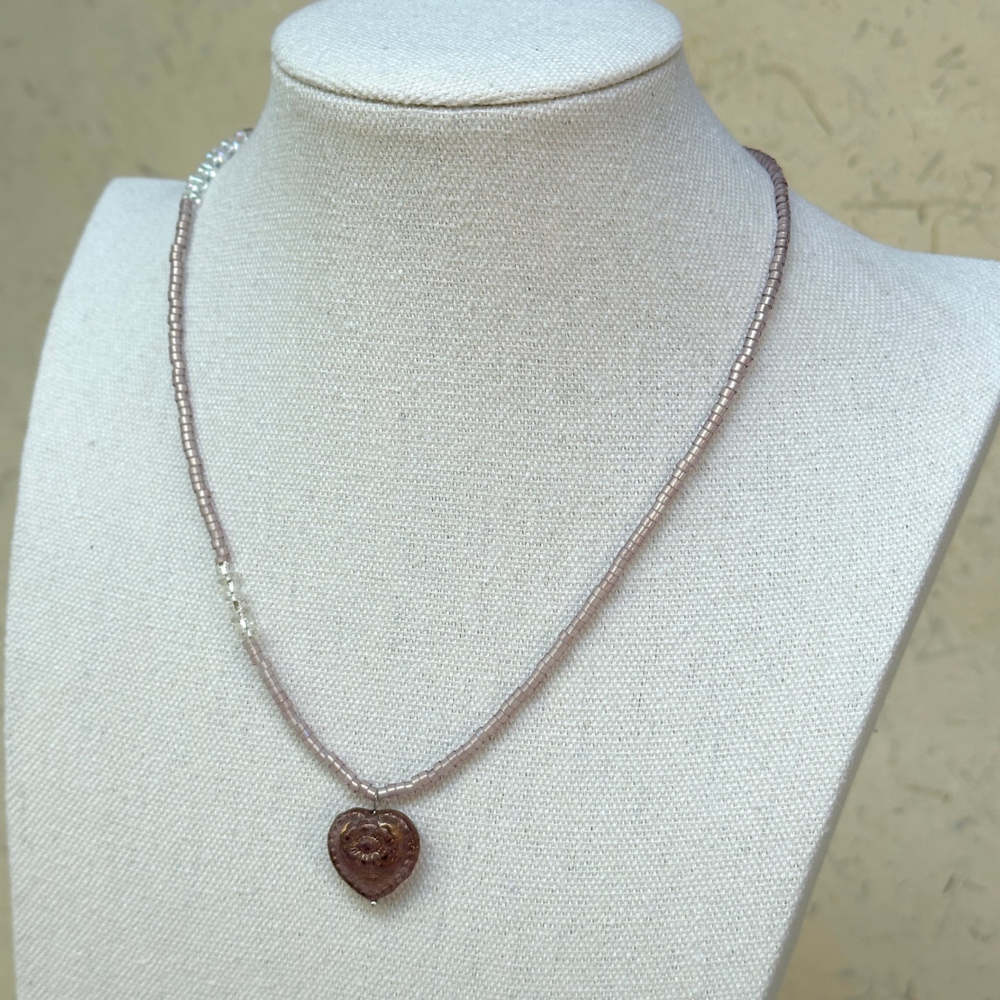 Pink Serenade Necklace worn on bust, highlighting romantic heart pendant with graceful blush-pink beads