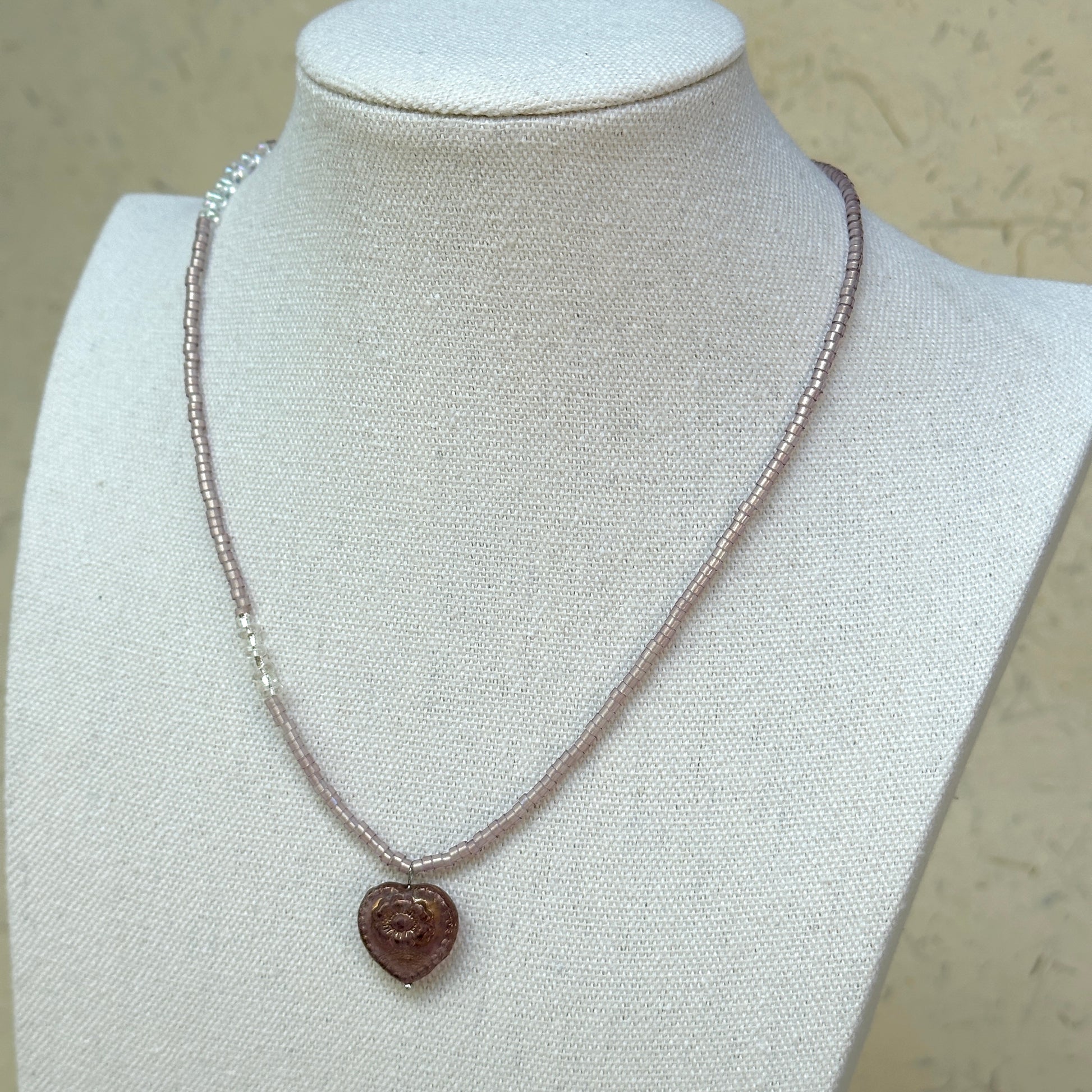 Pink Serenade Necklace worn on bust, highlighting romantic heart pendant with graceful blush-pink beads