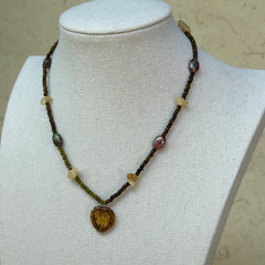 Aurora Heart Necklace worn on bust, showing romantic heart pendant with glowing gold details and colorful bead strand