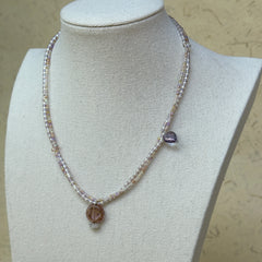 Iridescent Dew Necklace minimal styling on white fabric, emphasizing iridescent pastel glass beads and pendant detail
