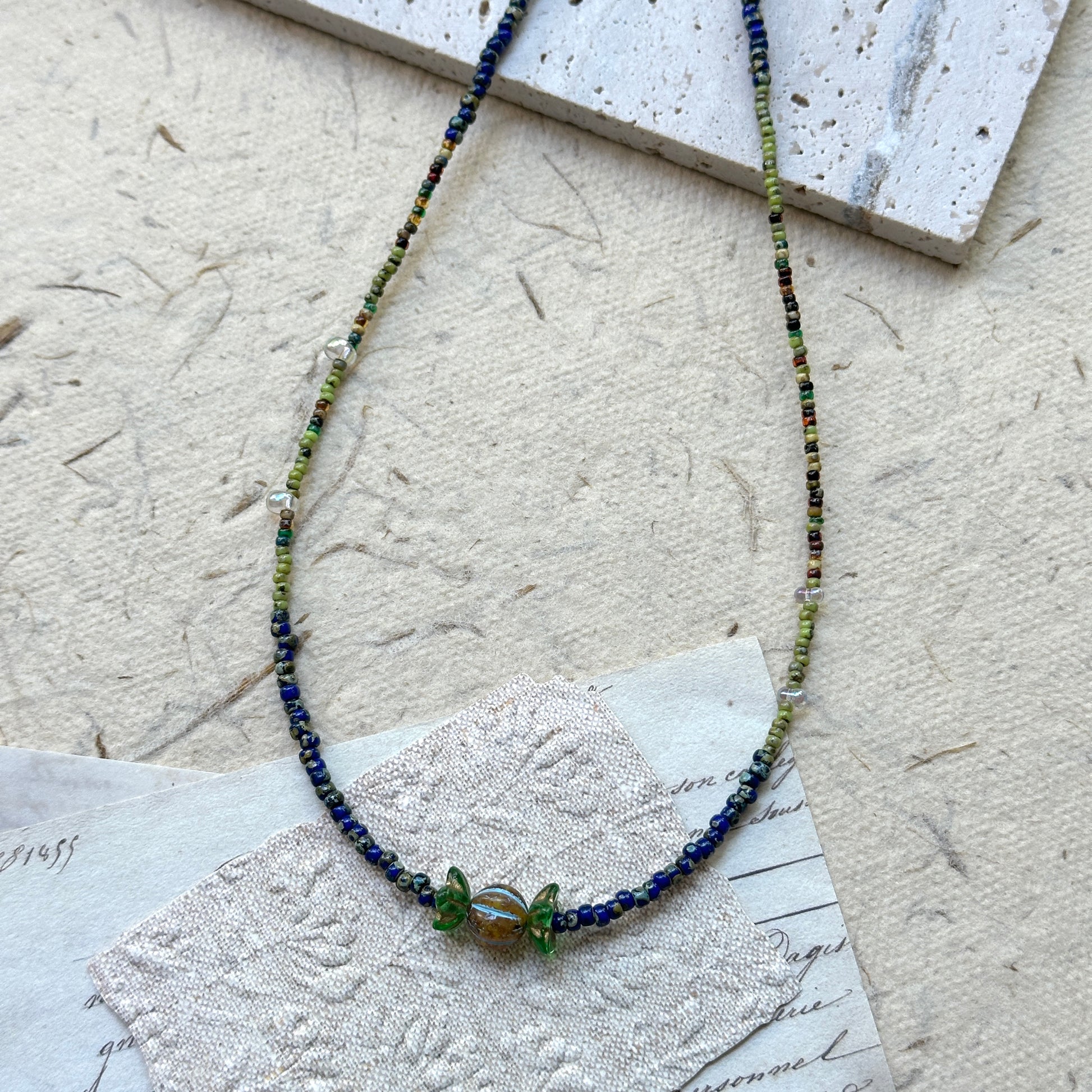 Close-up of wrapped-candy style glass pendant with green tint