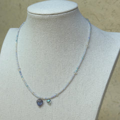 Celestial Love Necklace displayed on bust mannequin, emphasizing violet glass heart pendant and celestial blue accent