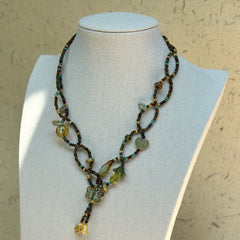 Olive Grove Lariat Necklace on a mannequin, draped lariat silhouette with adjustable drop; olive, moss and warm amber tones.