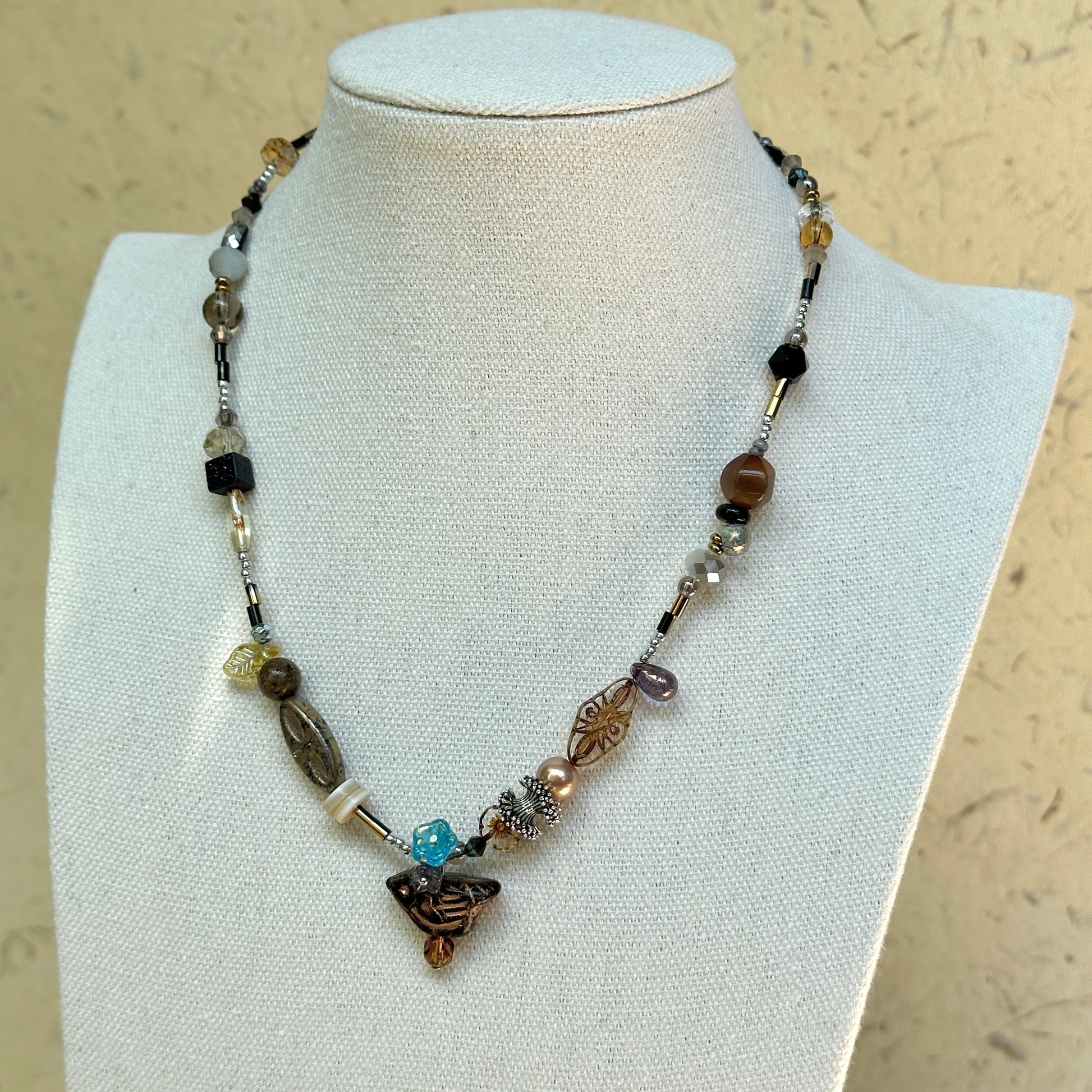 Nomad Relic Necklace on mannequin—smoky neutrals with bronze and onyx; easy to wear from everyday tees to evening knits.
