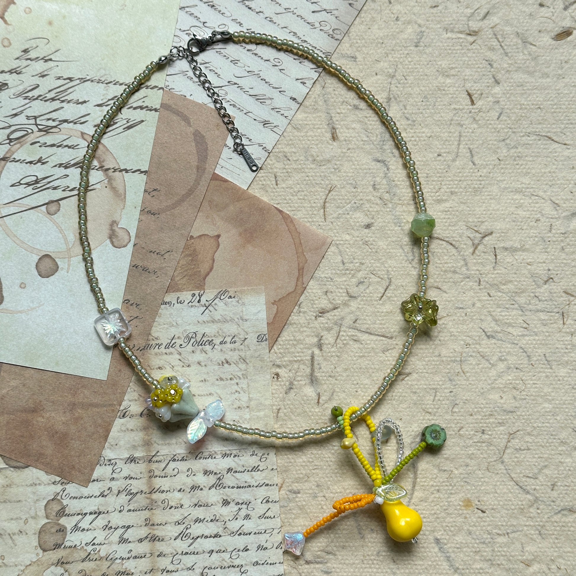 Close-up of yellow pear glass pendant with leaf and flower details
