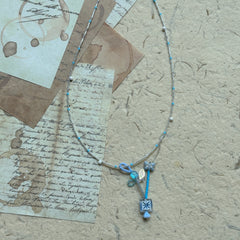 Angled flat lay highlighting crystal drops and frosted flower charms on the Frosted Sky Necklace; lightweight, luminous feel.