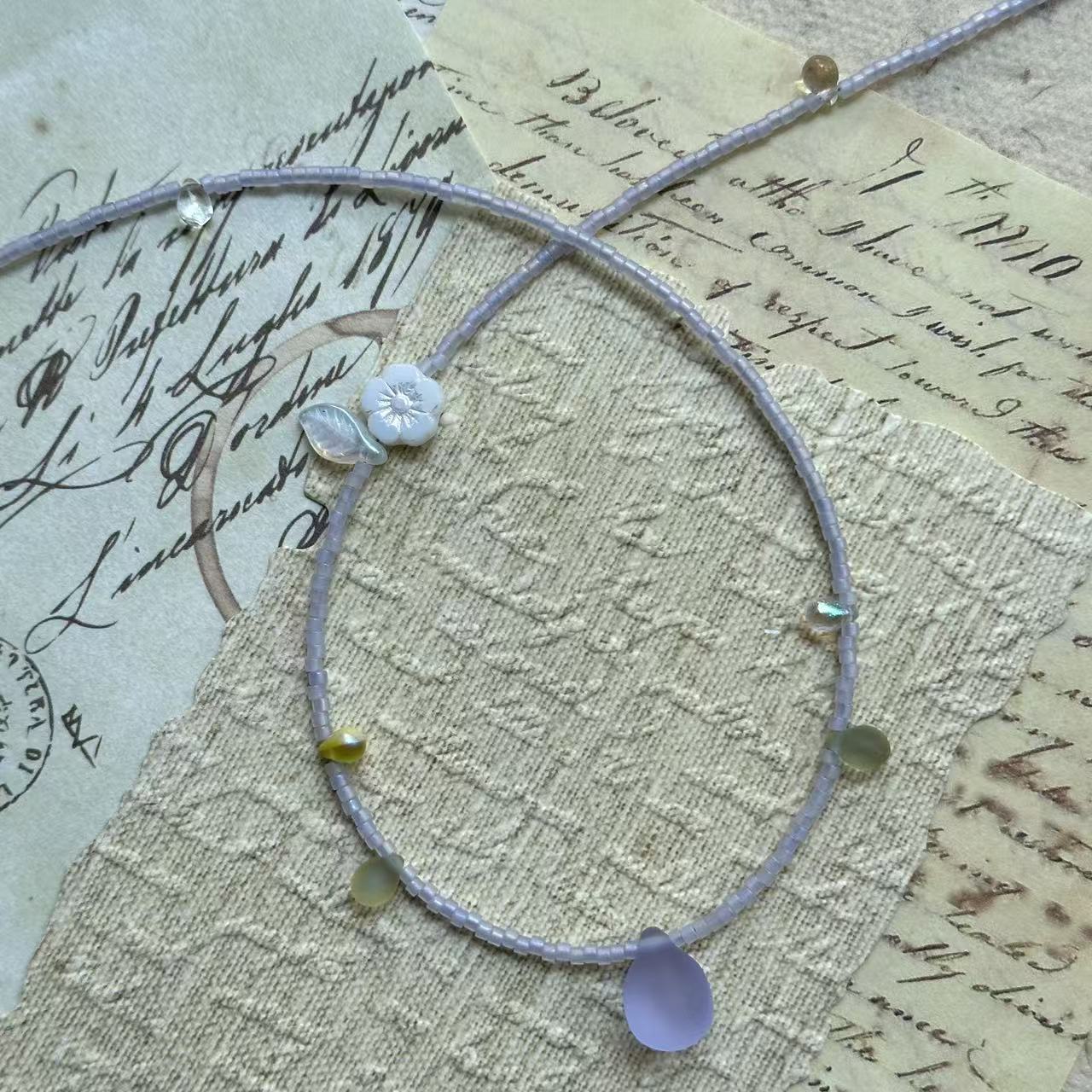 Close detail of Lilac Dew Necklace—lavender seed beads with a frosted lilac glass teardrop pendant; delicate and lightweight.