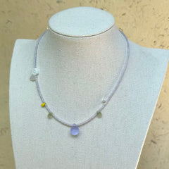 Lilac Dew Necklace on mannequin—delicate lavender strand with frosted lilac teardrop pendant; airy and easy to wear.