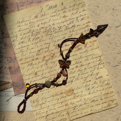 Midnight Butterfly Shadow Bracelet flat-lay on vintage script paper, crimson butterfly centerpiece with autumn leaf and glass accents